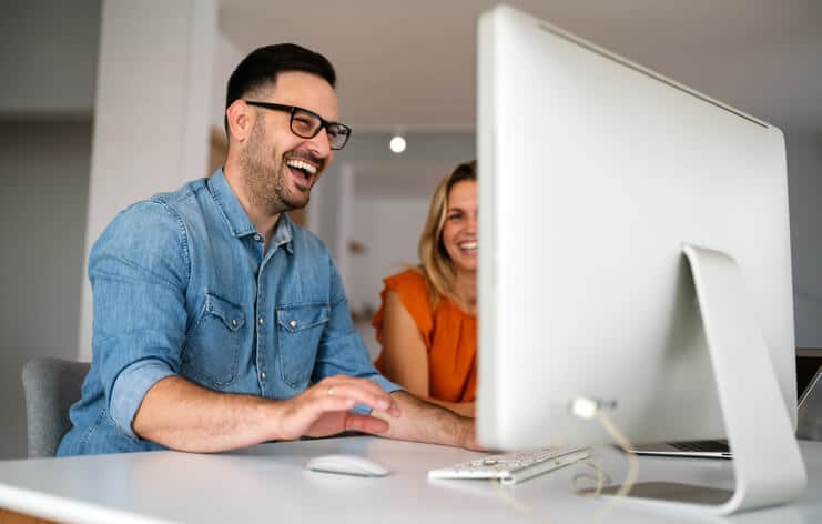 Two cyber security professionals working at their laptop after cybersecurity training