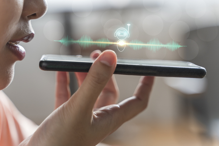 Digital marketing professional interacting with a virtual assistant on her phone after her digital marketing program