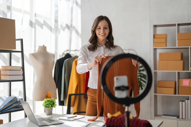 A female nano influencer showing different fashion items on a livestream