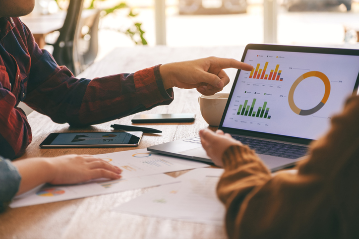 Expert en cours d’analyse des données travaillant sur un tableau de bord, montrant des graphiques et des statistiques en temps réel.