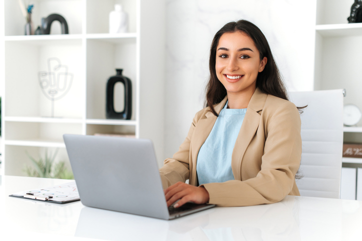 Smiling female digital marketing professional working in an office after completing her digital marketing training