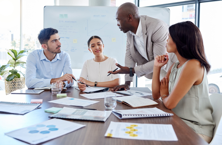 A marketing team brainstorming strategies using data-driven insights during a meeting after completing their digital marketing diploma