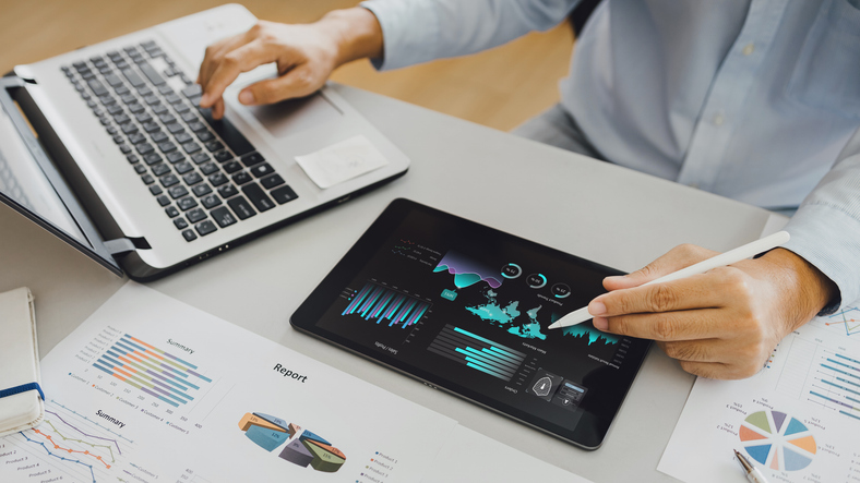 A professional marketer reviewing analytics data on a tablet for decision-making in a digital marketing campaign after completing his digital marketing diploma