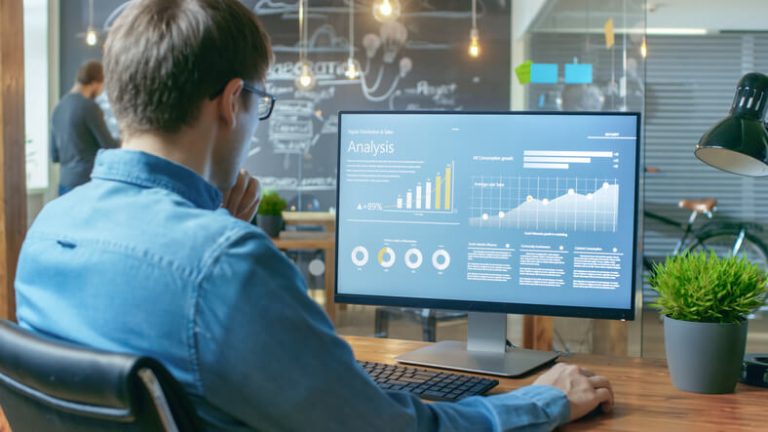 A digital marketing strategist analyzing campaign performance data on a computer screen.